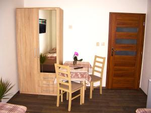 a wooden table and chairs in a room at Pension Krásno in Cheb