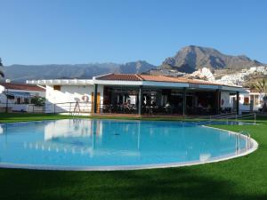 uma grande piscina azul em frente a um edifício em Heated Pool Sea view Speedy WiFi em Adeje