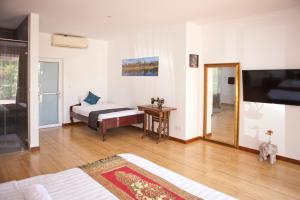 a living room with a bed and a television at Angkor Private villa Siem Reap in Siem Reap