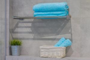a towel rack with blue towels in a bathroom at Apartamenty Laguna Przy Latarni in Darlowko +54 photos