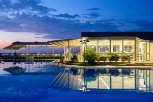 una casa con un reflejo en el agua por la noche en Marinos Beach Hotel, en Platanes