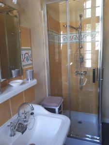 La salle de bains est pourvue d'un lavabo et d'une douche. dans l'établissement Chambres d'hôtes " Les Cascatelles", à Ax-les-Thermes