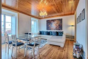 een woonkamer met een tafel en een bank bij Portas do Teatro Apartments in Lissabon