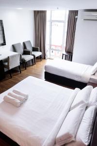 een hotelkamer met 2 bedden en een bank bij Classy Studio Apartment (KBCP) in Kota Bharu