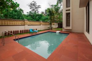 a swimming pool with a bench in a yard at StayVista's Greenwoods Villa 1 - City-Center Villa with Private Pool, Terrace, Lift & Carrom Board in Lonavala