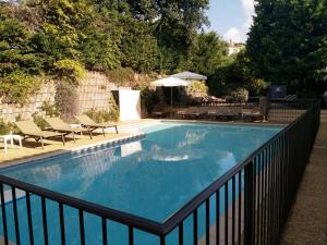 a swimming pool with a black fence around it at Hôtel Lou Paouvadou in Sainte-Maxime