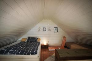 een slaapkamer met een bed op zolder bij Strandstuga in Tämta