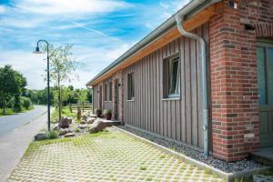 a brick building with a sidewalk next to a street at Ferienwohnung Spie in Sarkwitz