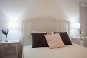 1 dormitorio con 1 cama blanca con almohadas y 2 lámparas en The Marvila - Modern 3 Bedroom Apartment in trendy New Lisbon en Lisboa