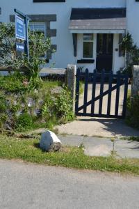 a fence in front of a house with a rock at Chyheira in Ruan Minor