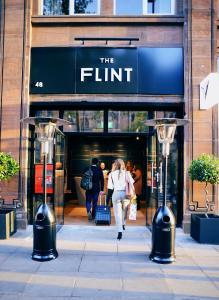 
a woman walking down a sidewalk next to a store at The Flint in Belfast
