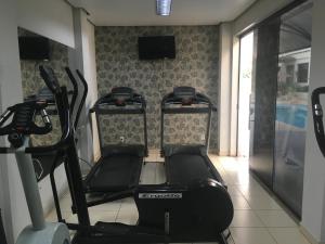 a gym with three exercise bikes and a television at Atrium Confort Hotels in Parauapebas