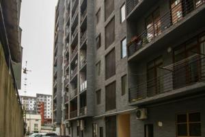 un edificio alto con balcones en una calle de la ciudad en Apartment Galaxy Didi Dighomi, en Tiflis