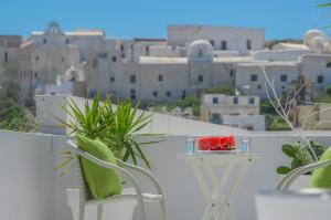 a table and chairs with a plate of watermelon on a balcony at Adriani Hotel in Naxos Chora