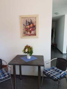 a table with a vase of flowers and two chairs at Apartment near Frankfurt, fantastic view! in Usingen