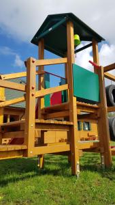 a wooden play house with a roof on top of it at Szumimorze in Rusinowo