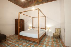 a bedroom with a canopy bed and a chair at Il Rigiuolo - Holiday Home in Vietri sul Mare