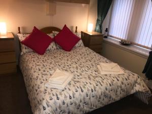 een slaapkamer met een bed met twee handdoeken erop bij Nelson Seaside Apartment in Largs