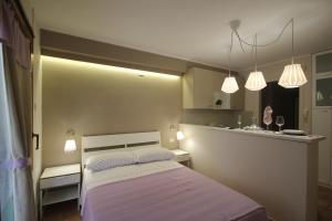a small bedroom with a bed and two lights at Cortile Aurora Bronte in Bronte
