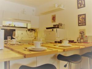 ヴィンターベルクにあるApartment Irene 011のキッチン(木製テーブル、皿、ワイングラス付)