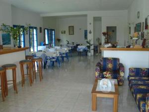 a living room with tables and chairs and a room with tables and chairs at Creta Sun Hotel Studios in Agia Pelagia