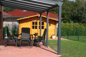 a pavilion with chairs and a table in front of a cabin at Ferienhaus Seepark in Walchum