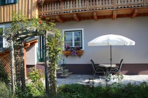 eine Terrasse mit einem Tisch und einem Sonnenschirm in der Unterkunft Ferienwohnung Brigitte in Bad Mitterndorf