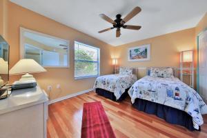 una camera da letto con due letti e un ventilatore a soffitto di Waterfront condo with community pools & hot tub - walk to the beach a St. Augustine Altre 51 foto