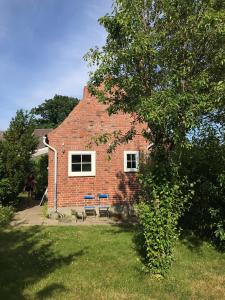 a brick house with a picnic table in front of it at Schoenes-Ferienhaus-mit-Garten-Mid-Century-Moebeln-in-Strand-naehe-Avendorf in Avendorf auf Fehmarn