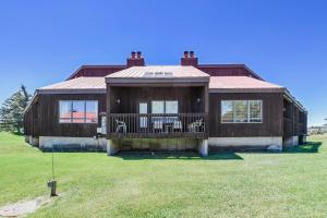 een groot houten huis met een veranda op een veld bij Aspenwood 4259 in Pagosa Springs