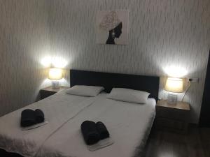 a bedroom with a bed with two hats and two lamps at Apartment Tamara On Khandzteli Street in Tbilisi City +13 photos