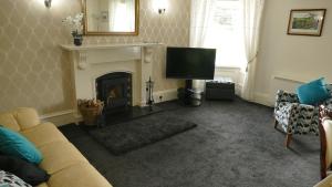 a living room with a couch and a fireplace at Riverside Apartments in Carluke