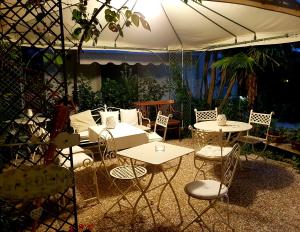 
a patio area with chairs, tables and umbrellas at Hotel La Primula in Forte dei Marmi
