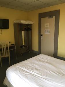 a bedroom with a bed and a desk and a television at Hostellerie d'Alsace in Cernay