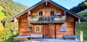 霍赫克尼希山麓丁騰的住宿－Selbstversorgerhütte Nösslau Alm，小木屋设有阳台和2张长椅