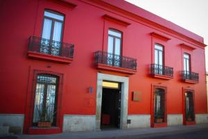 a red brick building with a red door at Hotel Abu in Oaxaca City