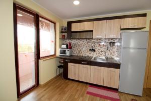 a kitchen with a refrigerator and a sink at Sauliaus apartamentai in Panevėžys