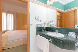 Hotel Soho Boutique Jerez في خيريز دي لا فرونتيرا: حمام مع حوض وسرير