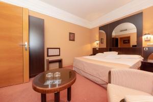 a hotel room with two beds and a table at Hotel Soho Boutique Jerez in Jerez de la Frontera +84 photos