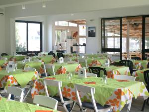 a banquet hall with green and orange tables and chairs at Camping Villaggio Lamaforca in Torre Santa Sabina