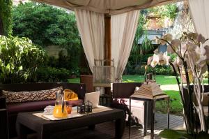 une terrasse avec un canapé et une table avec des oranges. dans l'établissement Hotel Fenix, à Rome