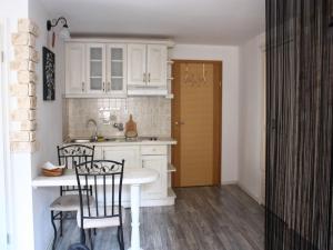 cocina con armarios blancos, mesa y sillas en Old Town Apartment en Šibenik