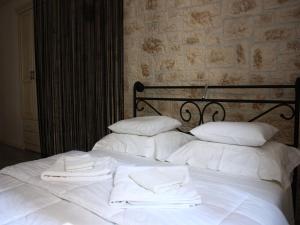 Una cama blanca con dos toallas blancas. en Old Town Apartment, en Šibenik