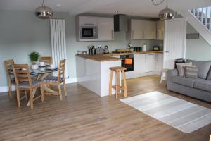 a kitchen and living room with a table and chairs at Laburnum Lodge room in Leeds