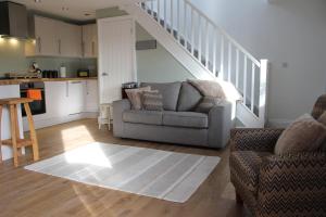 a living room with a couch and a staircase at Laburnum Lodge room in Leeds