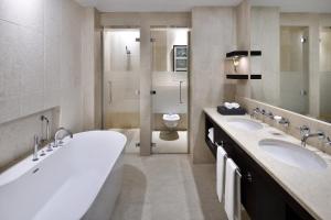 a bathroom with a sink, mirror, and bathtub at Address Montgomerie in Dubai