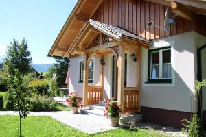 ein Haus mit einer Holzterrasse mit Topfpflanzen in der Unterkunft Ferienhaus Pürcher in Bad Mitterndorf