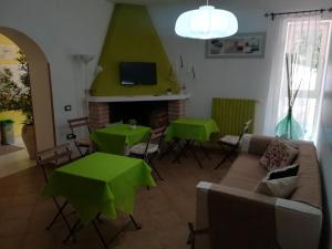 un soggiorno con tavoli verdi e un divano di La Noce Bed and Breakfast a Chieti