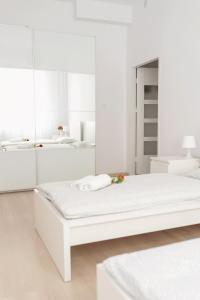 a white bedroom with a white bed and white cabinets at Apartament Różany in Gorzów Wielkopolski