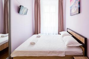 una camera da letto con un grande letto bianco e uno specchio di LEOGRAND Apartments on Stavropigiyska 7 a Lviv